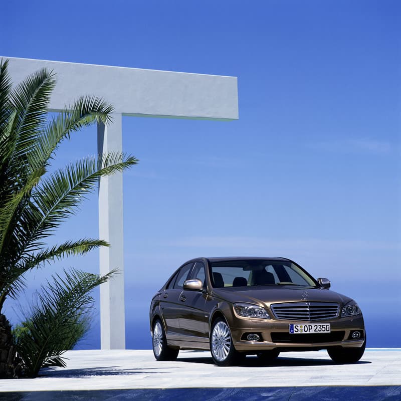 Front view parked under white architectural beams with palms