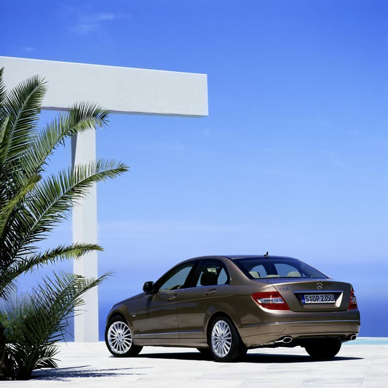 Rear view parked under white architectural beams with palms