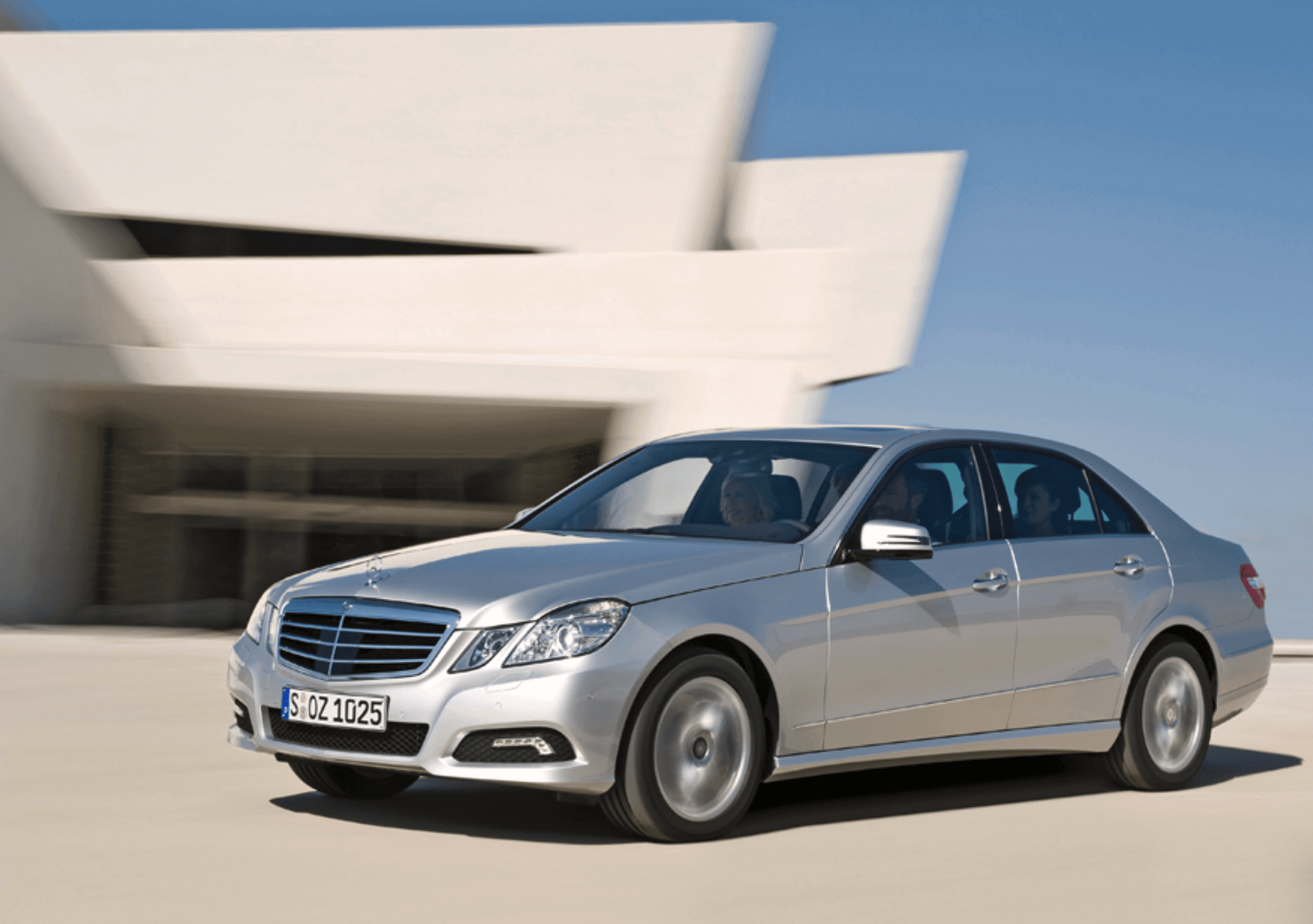 Dynamic front view of the car in motion near a white building