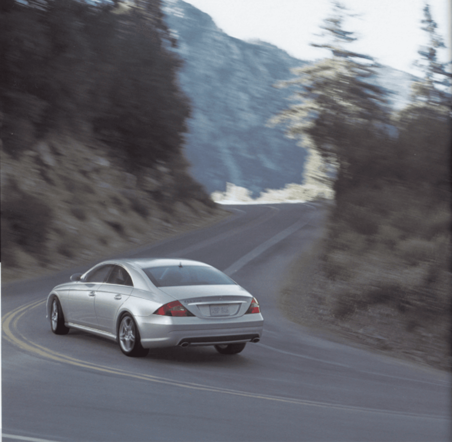Car driving on winding grey road